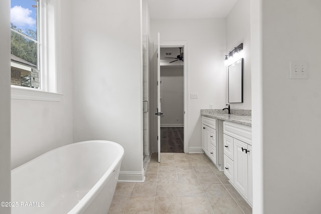 bathroom with tile patterned floors, a tub, and vanity