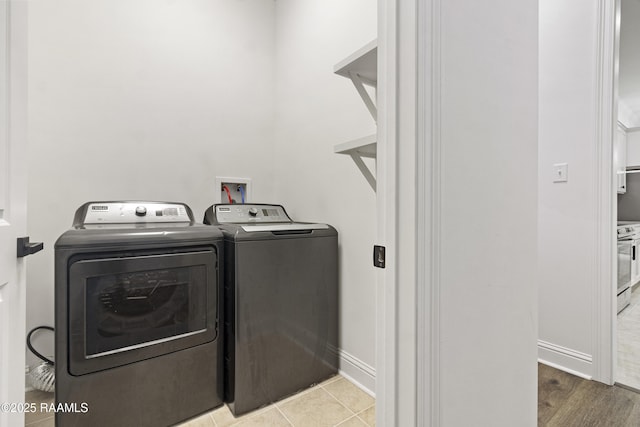 laundry room featuring light tile patterned flooring and washing machine and dryer