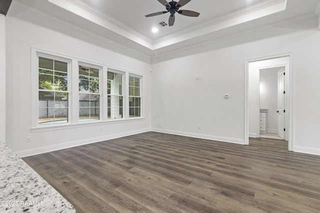 unfurnished room with a raised ceiling, ceiling fan, and dark hardwood / wood-style flooring