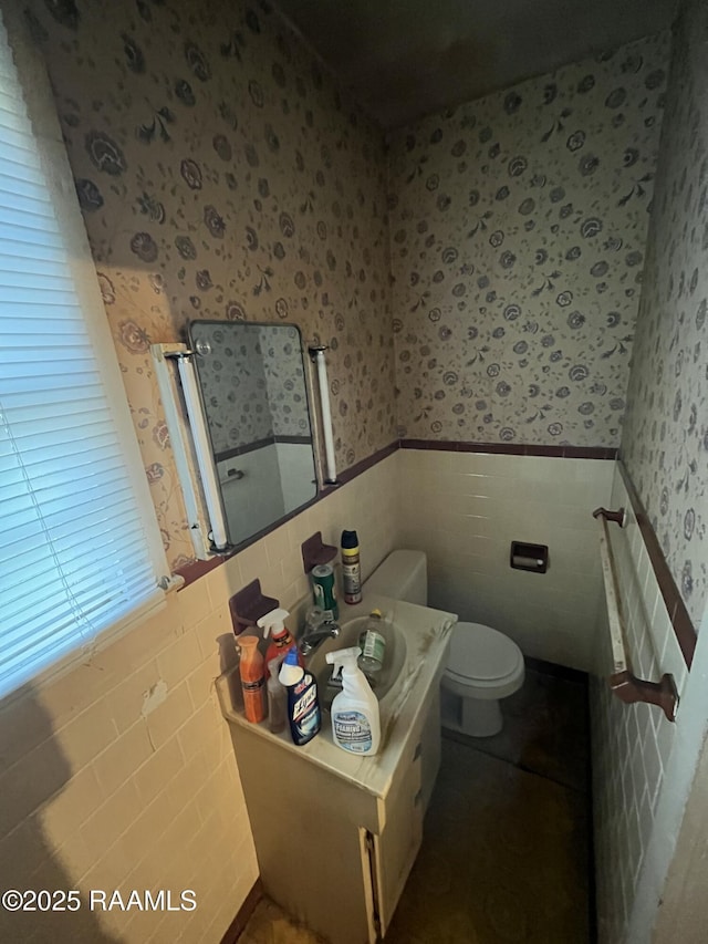 bathroom featuring toilet and tile walls