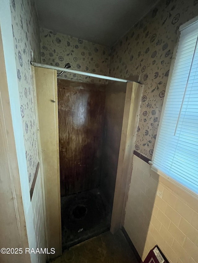 bathroom featuring tile walls and a shower