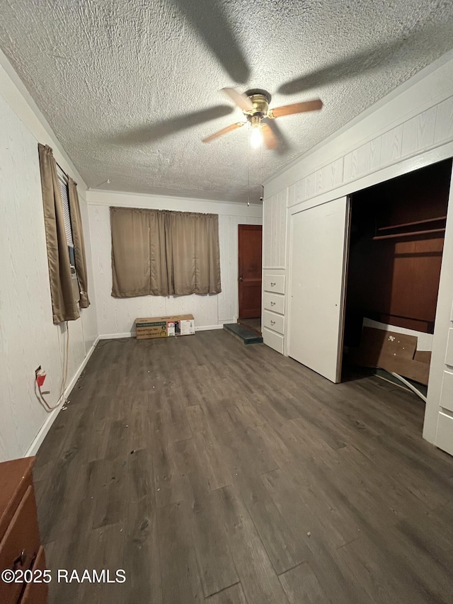 unfurnished bedroom featuring ceiling fan, dark hardwood / wood-style floors, and a textured ceiling