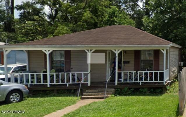 bungalow-style home featuring covered porch and a front yard