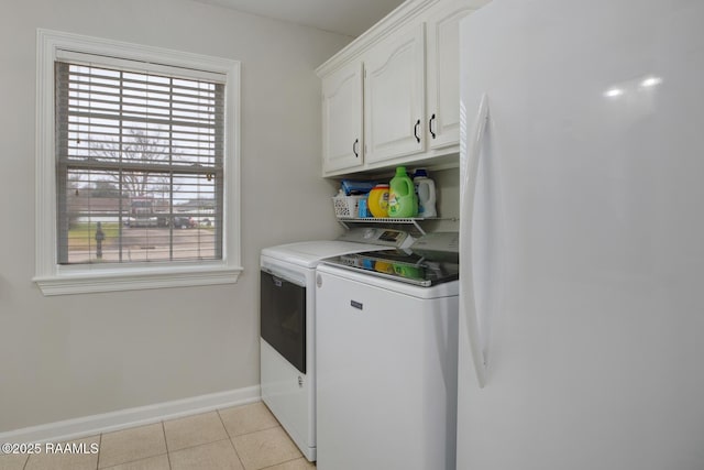 washroom featuring light tile patterned flooring, cabinets, and washer and clothes dryer