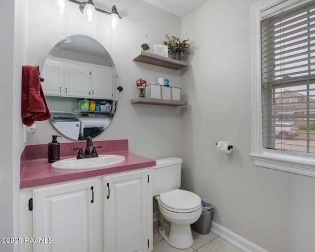 bathroom featuring vanity, washing machine and clothes dryer, tile patterned floors, and toilet