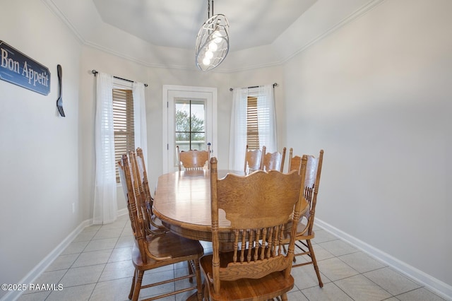 tiled dining space featuring a raised ceiling