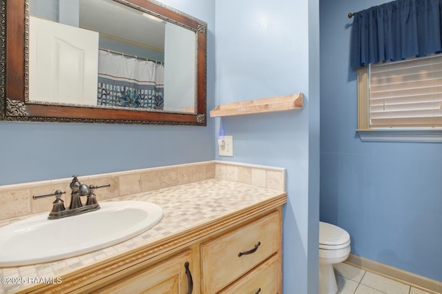 bathroom with tile patterned flooring, vanity, and toilet