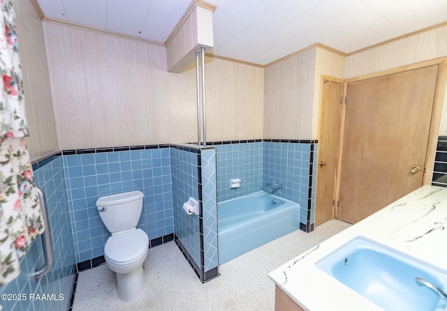 bathroom featuring tile walls, toilet, vanity, and a bathing tub