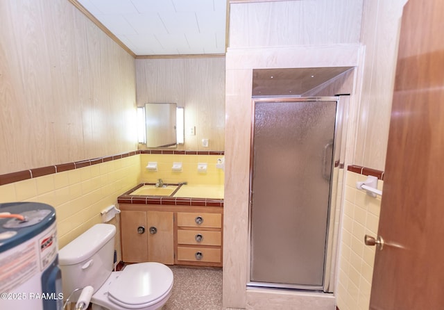 bathroom with an enclosed shower, tile walls, sink, and toilet