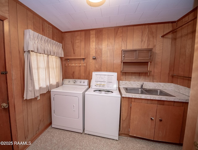 laundry room featuring sink, separate washer and dryer, and wooden walls