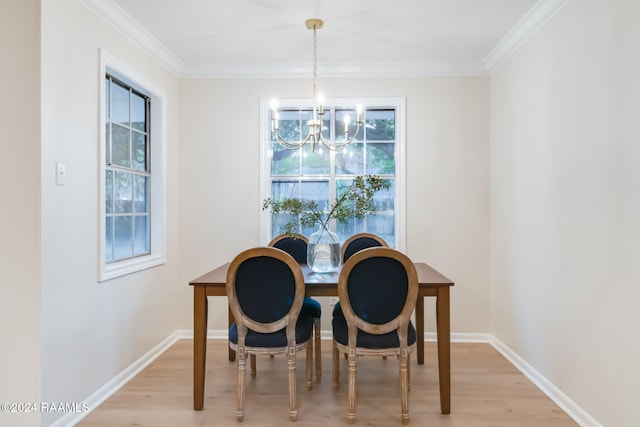 dining room with an inviting chandelier, ornamental molding, and light hardwood / wood-style flooring