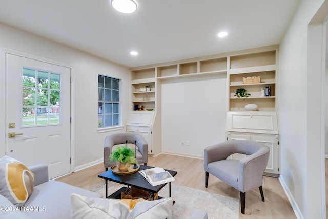 sitting room featuring built in shelves and light hardwood / wood-style floors