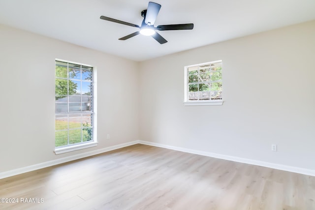 empty room with ceiling fan and light hardwood / wood-style flooring