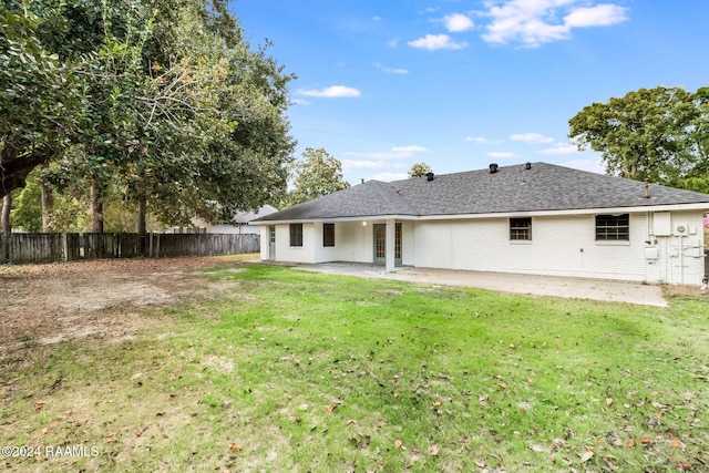 back of house featuring a patio and a lawn