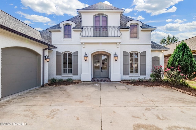 french country inspired facade with a balcony and a garage