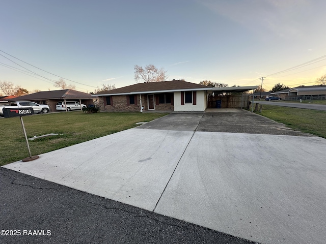 single story home featuring a carport and a lawn