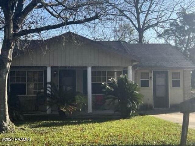 view of front of house featuring covered porch and a front lawn