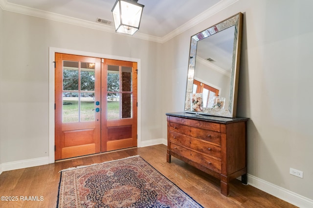 foyer entrance with crown molding, french doors, and hardwood / wood-style flooring