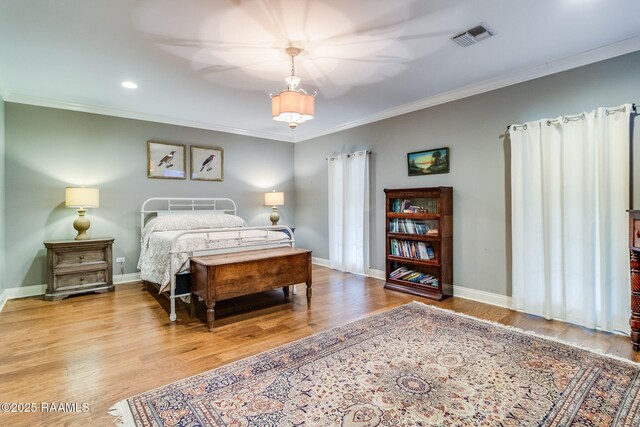 bedroom with crown molding and hardwood / wood-style flooring