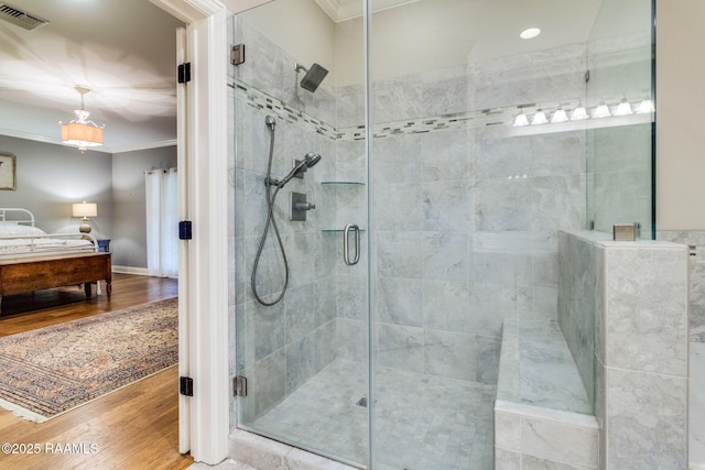 bathroom featuring crown molding, wood-type flooring, and a shower with door