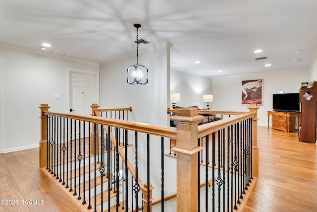 hall featuring ornamental molding, a notable chandelier, and light hardwood / wood-style flooring