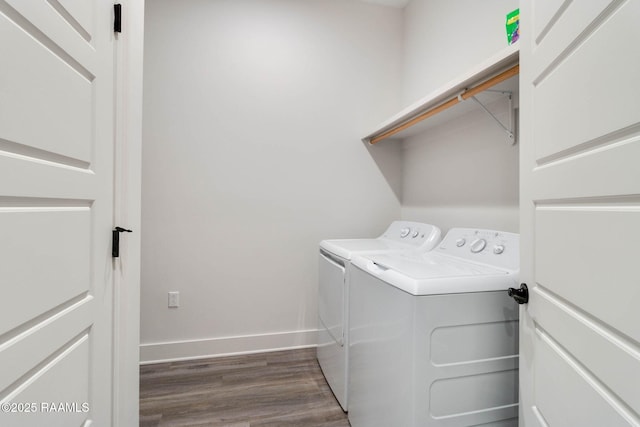 clothes washing area with washer and dryer and dark wood-type flooring