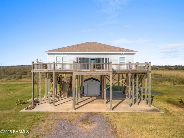 rear view of house featuring a storage shed, a yard, a patio area, and a wooden deck