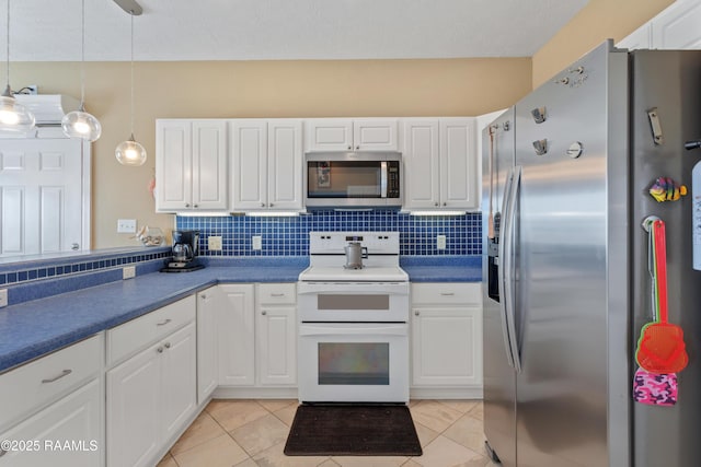 kitchen featuring stainless steel appliances, white cabinetry, pendant lighting, and light tile patterned flooring