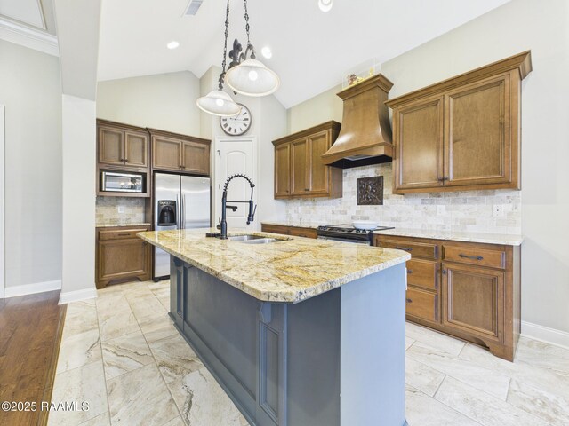 208 Rue De Frejus, Broussard, LA 70518 - kitchen featuring a sink, premium range hood, appliances with stainless steel finishes, a center island with sink, and light stone counters