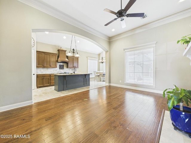 208 Rue De Frejus, Broussard, LA 70518 - unfurnished living room featuring light wood finished floors, a ceiling fan, arched walkways, recessed lighting, and a chandelier