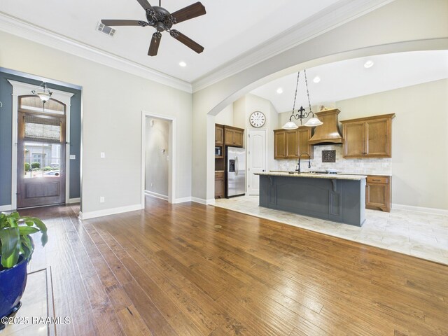 208 Rue De Frejus, Broussard, LA 70518 - kitchen with stainless steel refrigerator with ice dispenser, premium range hood, brown cabinets, a ceiling fan, and light countertops