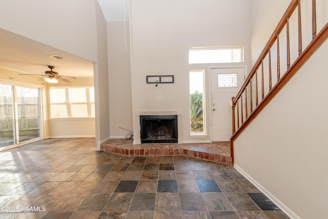 entrance foyer with ceiling fan and a high ceiling