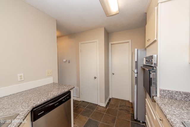 kitchen featuring a textured ceiling, stainless steel appliances, and sink