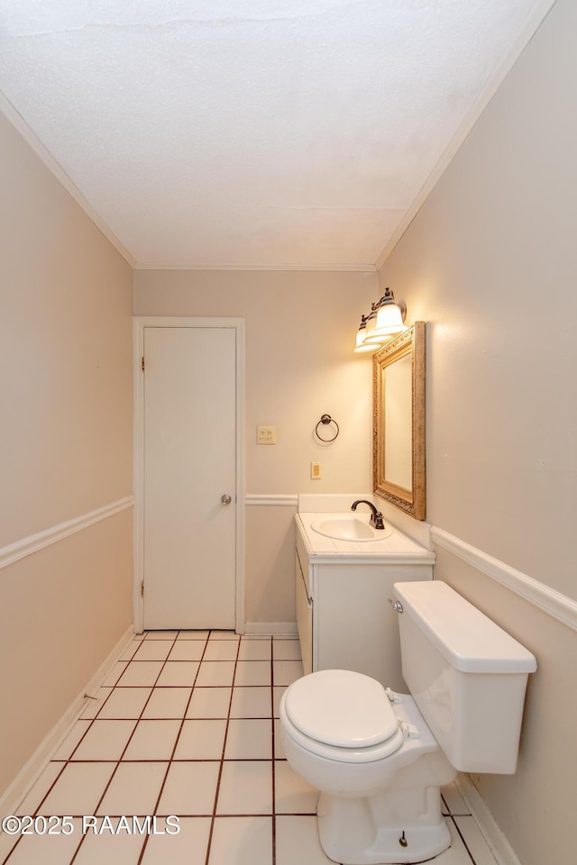 bathroom with tile patterned floors, toilet, vanity, and crown molding