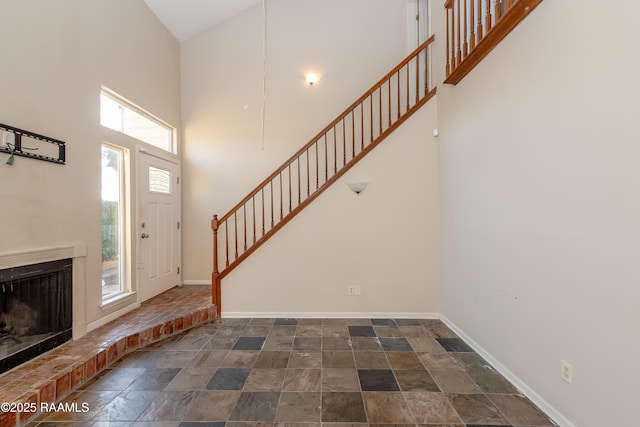 entrance foyer with a towering ceiling and a fireplace