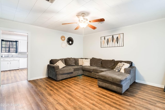 living room with crown molding, ceiling fan, and wood-type flooring