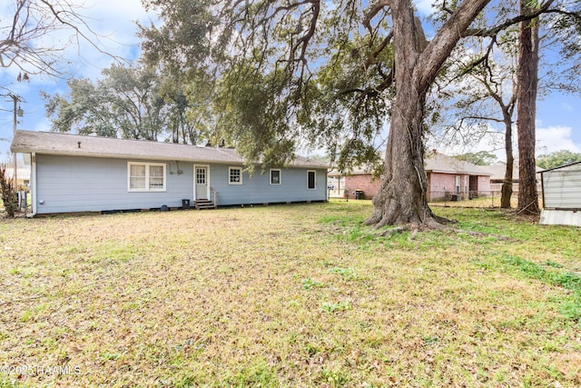 rear view of house featuring a yard