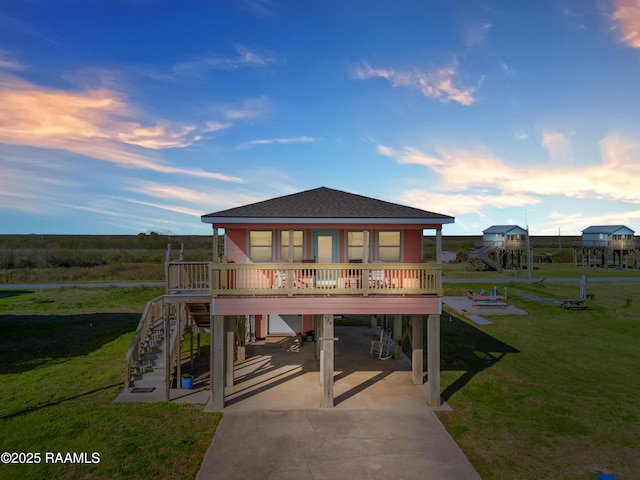 view of front facade featuring a carport, a porch, and a lawn