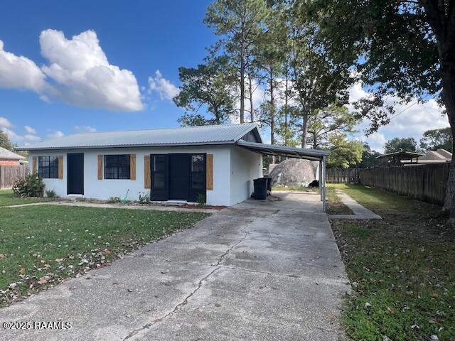 view of front of property with a front yard and a carport