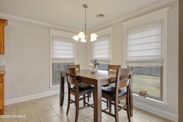 dining space with light tile patterned flooring, ornamental molding, and a notable chandelier