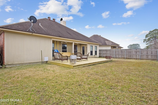 back of house featuring a deck and a lawn