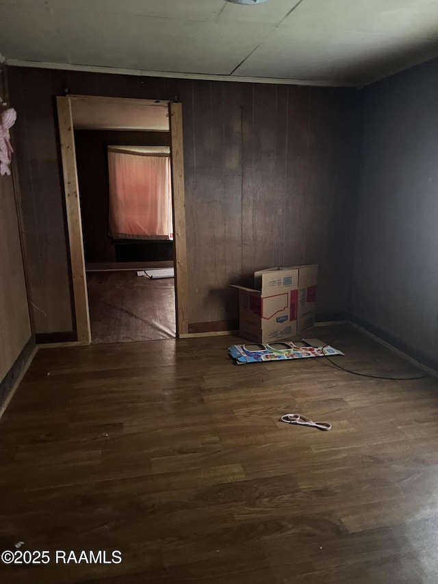 unfurnished room featuring dark hardwood / wood-style flooring and wood walls