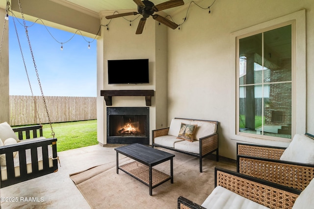 view of patio / terrace with ceiling fan and an outdoor living space with a fireplace