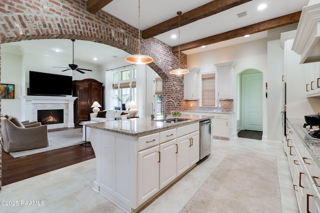 kitchen featuring sink, pendant lighting, an island with sink, and white cabinetry