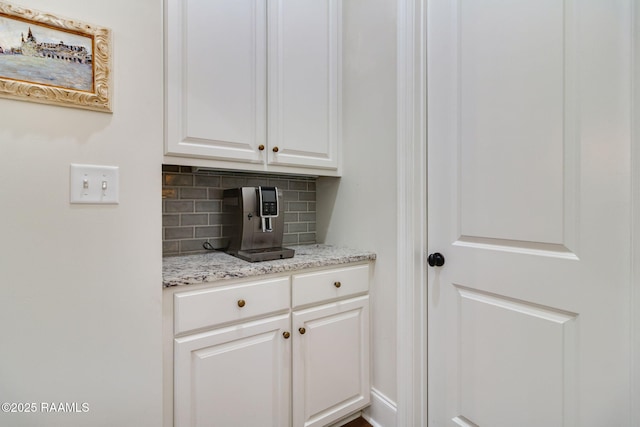 bar featuring white cabinetry, light stone counters, and tasteful backsplash