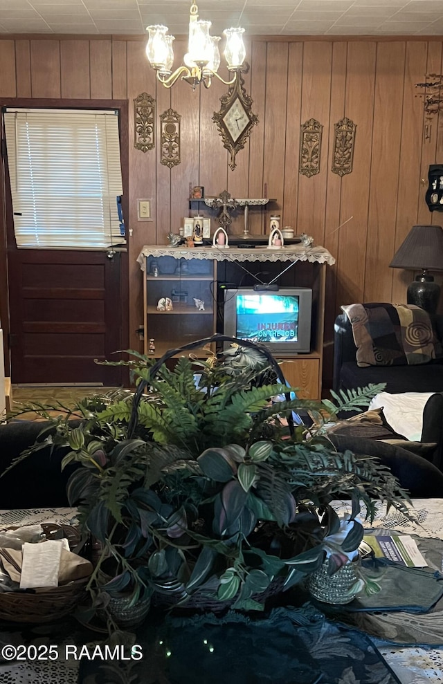 misc room featuring a notable chandelier and wooden walls