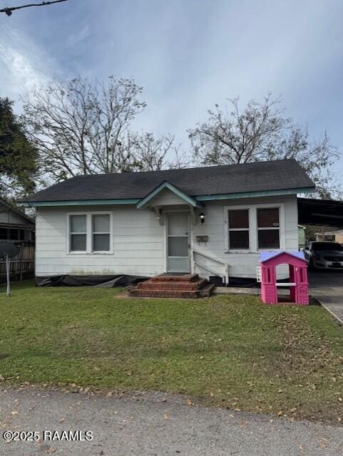 view of front of property featuring a front yard and a carport