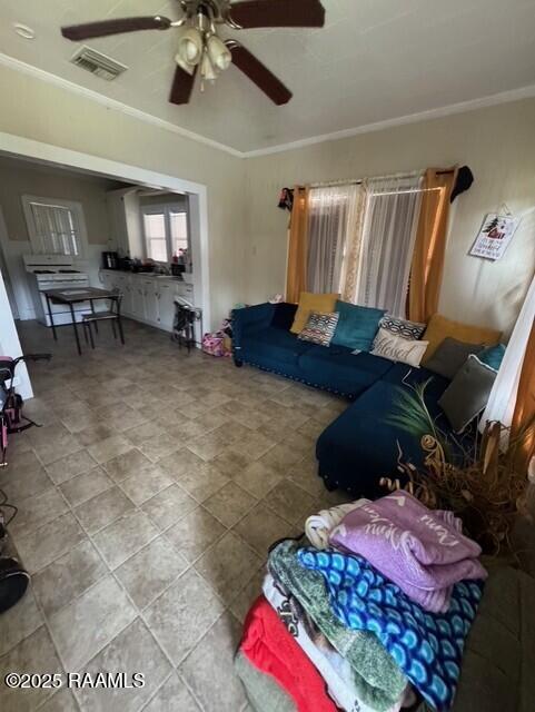 living room with ceiling fan and ornamental molding