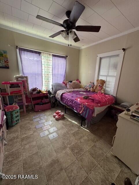 bedroom with ceiling fan and crown molding