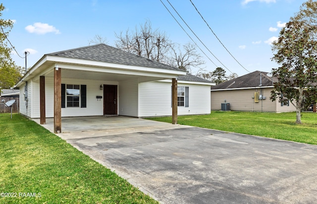 view of front facade with cooling unit, a front yard, and a carport